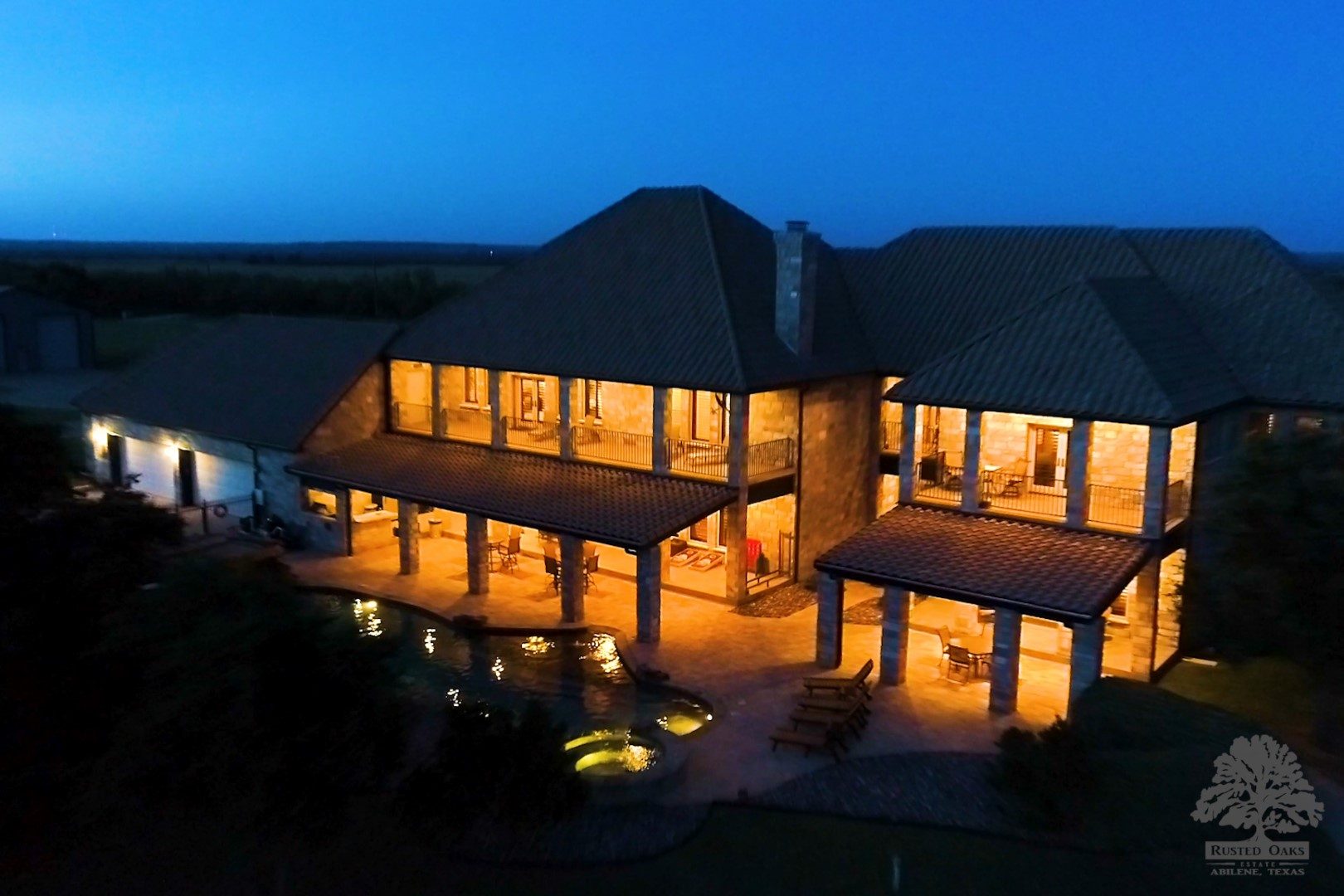 Aerial night shot of Rusted Oaks Estate glowing against West Texas sky