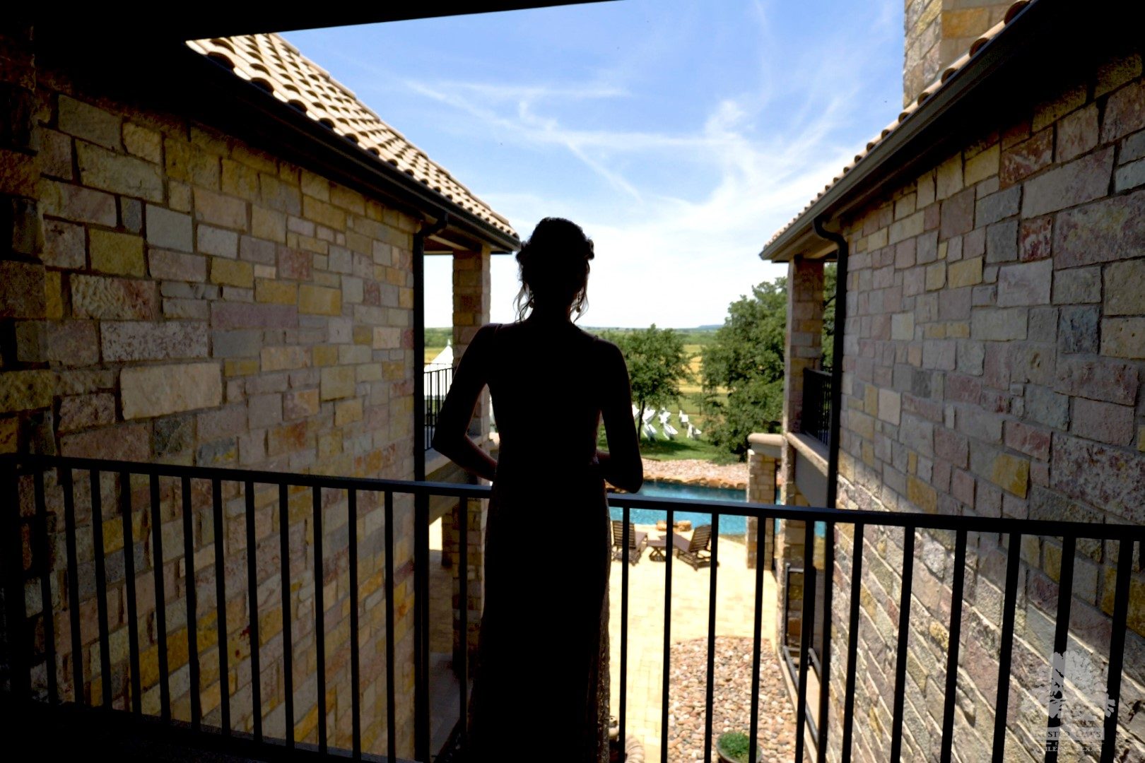 Silhouette on the balcony at Rusted Oaks Estate overlooking the pool and West Texas